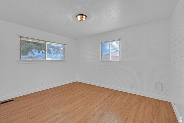 8693 S Vaquero Dr, Sandy, UT 84094 - unfurnished room featuring plenty of natural light, visible vents, light wood finished floors, and a textured ceiling