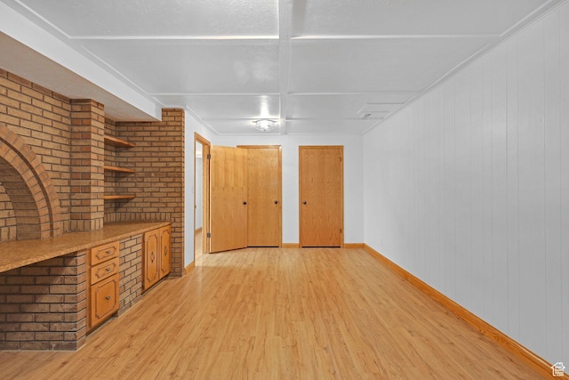 8693 S Vaquero Dr, Sandy, UT 84094 - empty room featuring light wood-style floors, baseboards, and brick wall