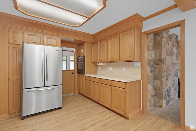 8693 S Vaquero Dr, Sandy, UT 84094 - kitchen featuring light countertops, black oven, light wood-type flooring, and freestanding refrigerator