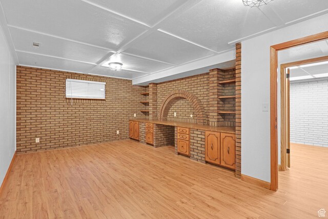 8693 S Vaquero Dr, Sandy, UT 84094 - unfurnished living room featuring light wood-style flooring, baseboards, and brick wall