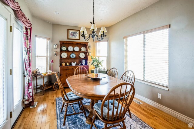 9575 Aztec Dr, Cedar Hills, UT 84062 - dining space featuring a chandelier, plenty of natural light, and light wood finished floors