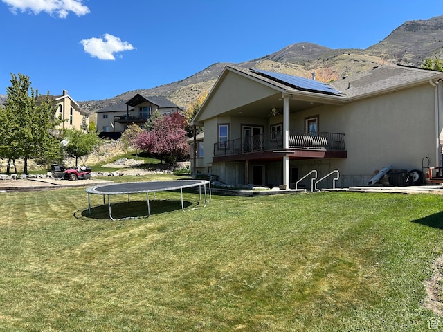 9575 Aztec Dr, Cedar Hills, UT 84062 - rear view of property featuring a yard, solar panels, a mountain view, and a trampoline