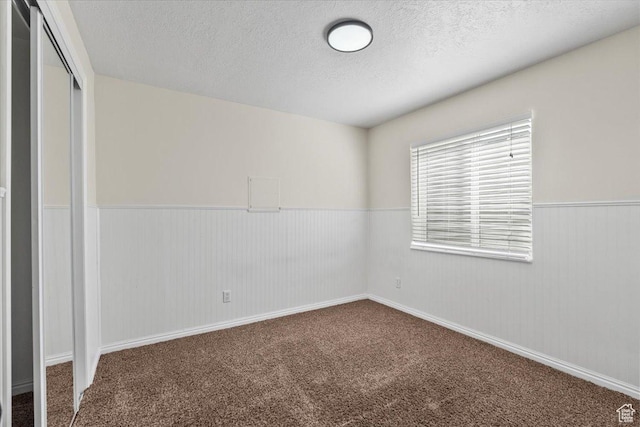 2419 N Nectar Way, Saratoga Springs, UT 84045 - unfurnished bedroom featuring a textured ceiling, wainscoting, a closet, and carpet flooring