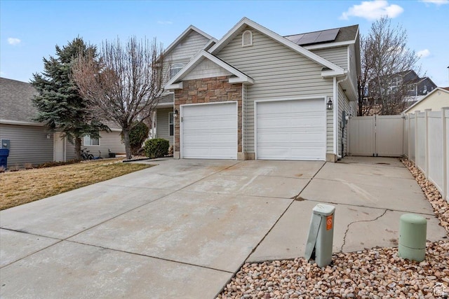 2419 N Nectar Way, Saratoga Springs, UT 84045 - traditional home featuring solar panels, driveway, stone siding, and a gate