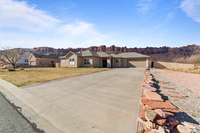 4224 Valle Del Sol, Moab, UT 84532 - ranch-style home featuring an attached garage, fence, driveway, stucco siding, and a front yard
