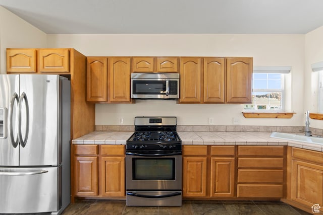 4224 Valle Del Sol, Moab, UT 84532 - kitchen with brown cabinetry, tile counters, stainless steel appliances, and a sink