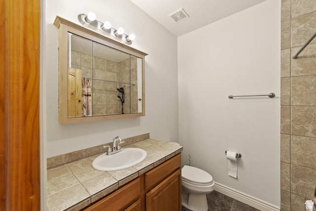 4224 Valle Del Sol, Moab, UT 84532 - bathroom with toilet, vanity, visible vents, baseboards, and tiled shower