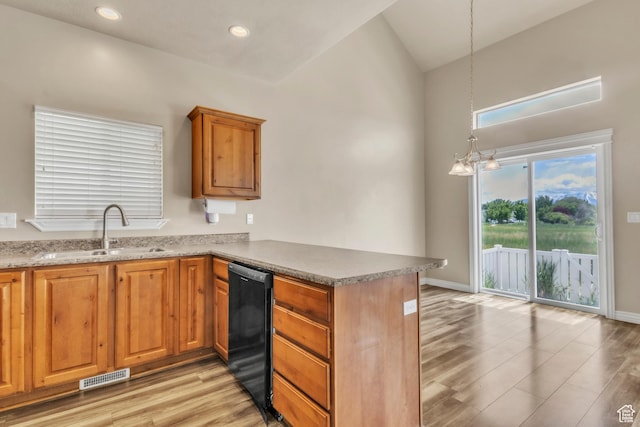 1351 Westbridge Cir, Provo, UT 84601 - kitchen with a sink, a peninsula, black dishwasher, light wood-style flooring, and brown cabinetry