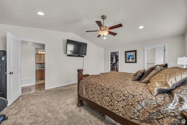 bedroom with visible vents, connected bathroom, carpet flooring, a spacious closet, and vaulted ceiling