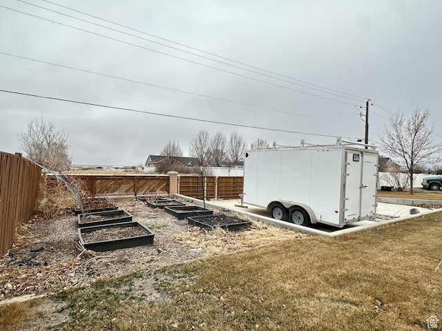 view of yard featuring fence and a garden
