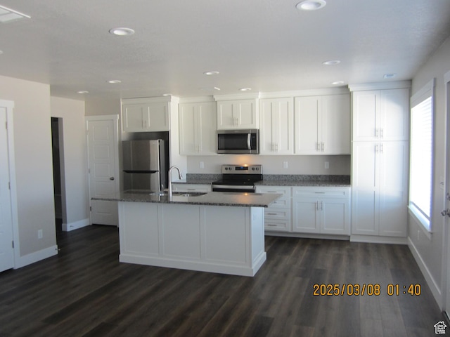 kitchen featuring a sink, white cabinets, an island with sink, and stainless steel appliances