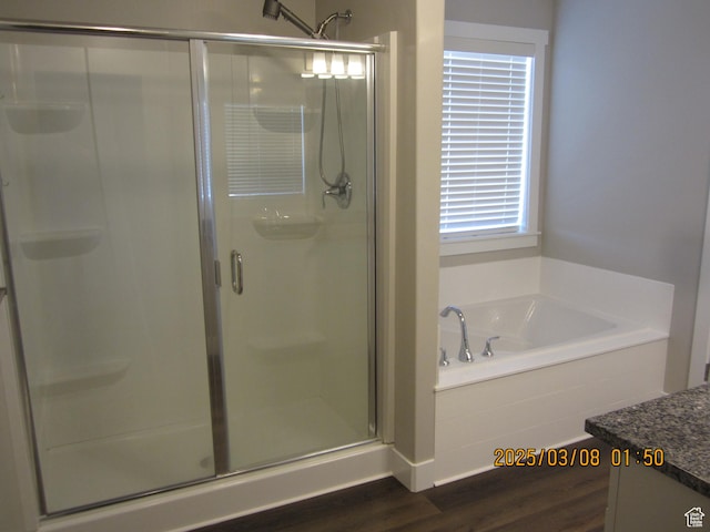 full bath with wood finished floors, vanity, a bath, and a shower stall