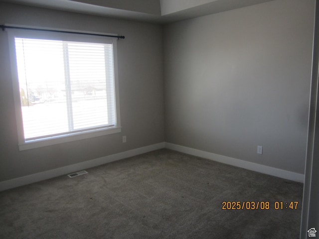 carpeted spare room featuring baseboards and visible vents