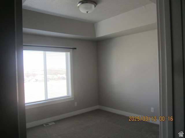 unfurnished room featuring carpet and baseboards
