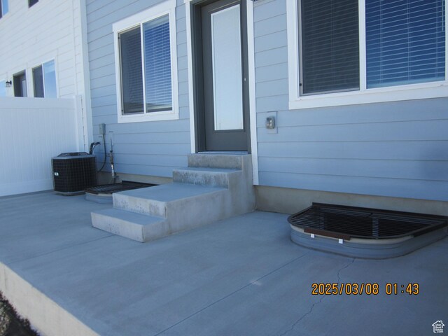 property entrance with cooling unit and fence