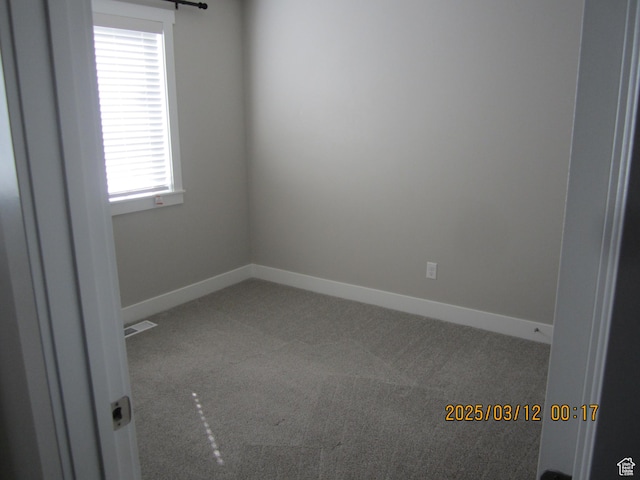 carpeted empty room with visible vents and baseboards