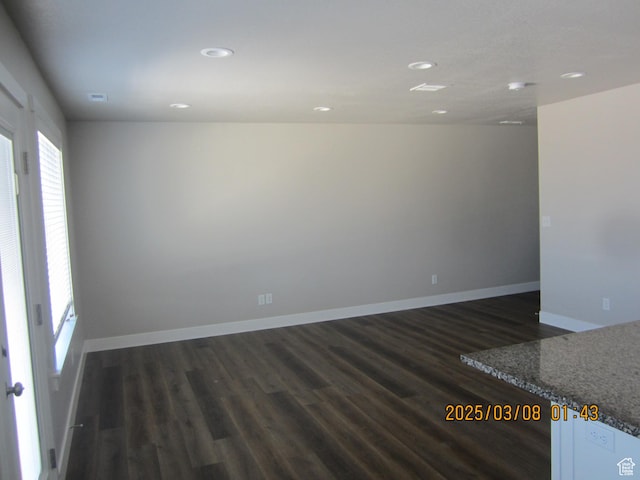 unfurnished room with dark wood finished floors, recessed lighting, and baseboards