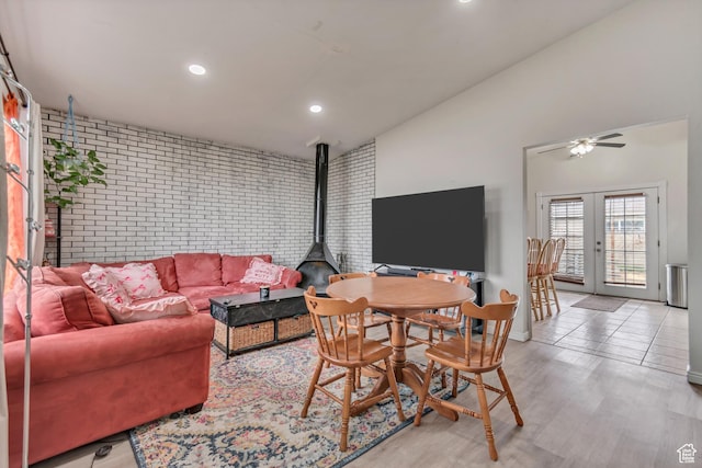 3734 S Bannock St, West Valley City, UT 84120 - living room featuring french doors, lofted ceiling, light wood-style flooring, a wood stove, and brick wall