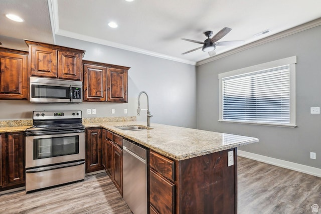 2887 N 1175 W, Layton, UT 84041 - kitchen featuring a peninsula, a sink, ornamental molding, appliances with stainless steel finishes, and light wood finished floors