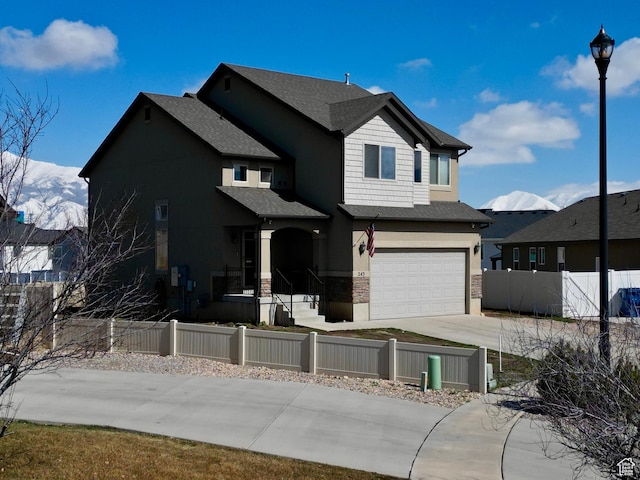 view of front of home featuring driveway, a fenced front yard, and an attached garage