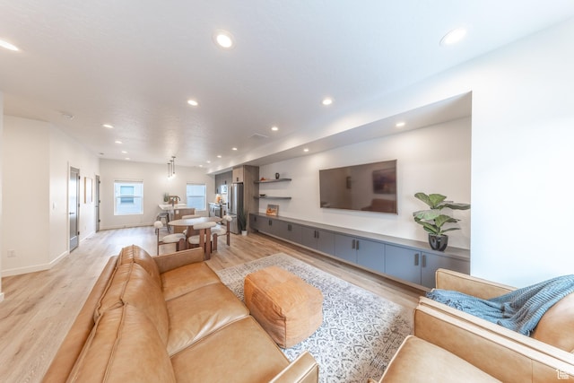 living room with light wood-type flooring, baseboards, and recessed lighting