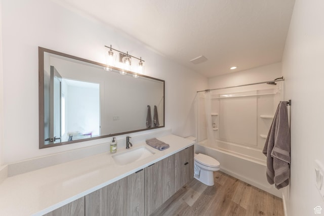 full bath with toilet,  shower combination, wood finished floors, and vanity