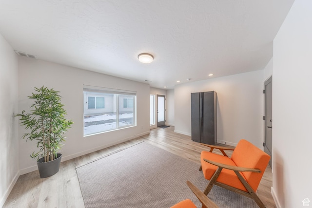 sitting room with baseboards, recessed lighting, and light wood-style floors