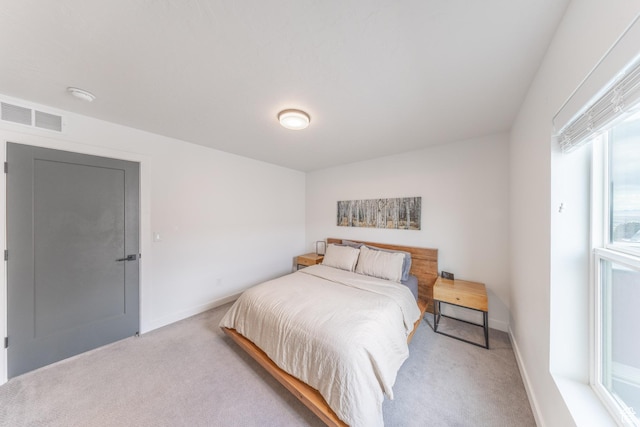 bedroom featuring light colored carpet, visible vents, and baseboards