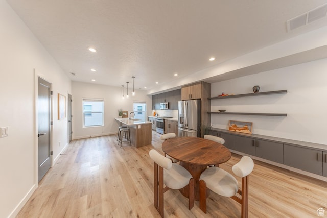 dining area featuring light wood finished floors, visible vents, and recessed lighting