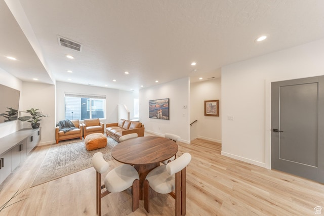 dining area with baseboards, light wood-style flooring, visible vents, and recessed lighting