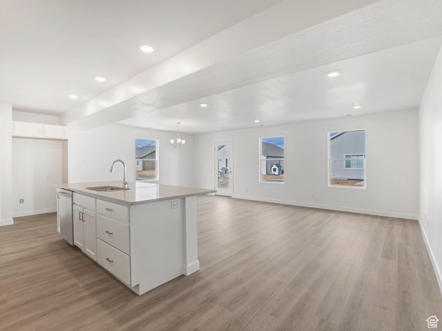1604 E Pheasant Rd Unit 208, Eagle Mountain, UT 84005 - kitchen with light wood-type flooring, a center island with sink, a sink, stainless steel dishwasher, and white cabinets