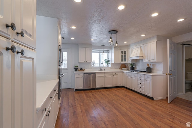 1045 Fox Farm Rd, Logan, UT 84321 - kitchen featuring custom range hood, appliances with stainless steel finishes, dark wood-type flooring, white cabinets, and a sink