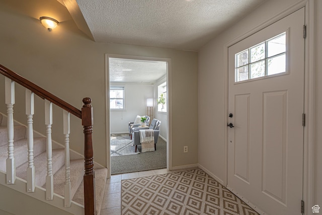 1045 Fox Farm Rd, Logan, UT 84321 - foyer entrance featuring stairs, baseboards, a textured ceiling, and light tile patterned flooring