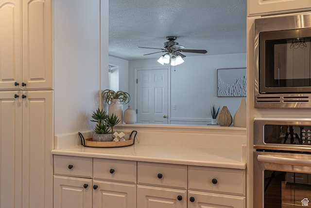 1045 Fox Farm Rd, Logan, UT 84321 - kitchen featuring light countertops, appliances with stainless steel finishes, a ceiling fan, white cabinetry, and a textured ceiling
