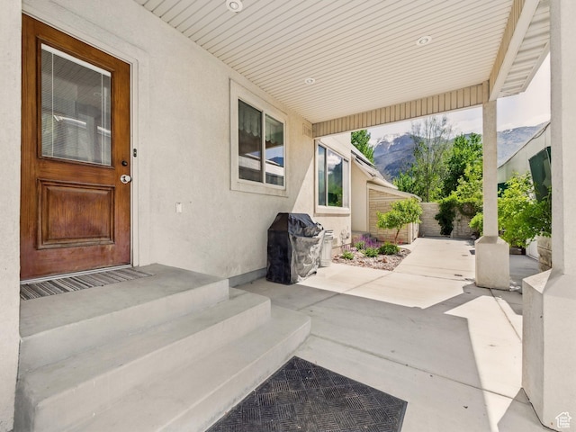 view of patio / terrace with fence and a mountain view