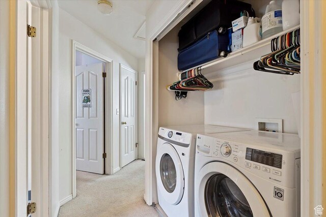 laundry room featuring washing machine and dryer, laundry area, and light carpet
