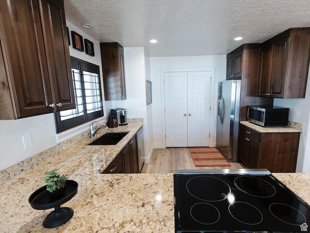 926 N 165 W, Nephi, UT 84648 - kitchen with light stone counters, appliances with stainless steel finishes, a sink, a textured ceiling, and dark brown cabinets