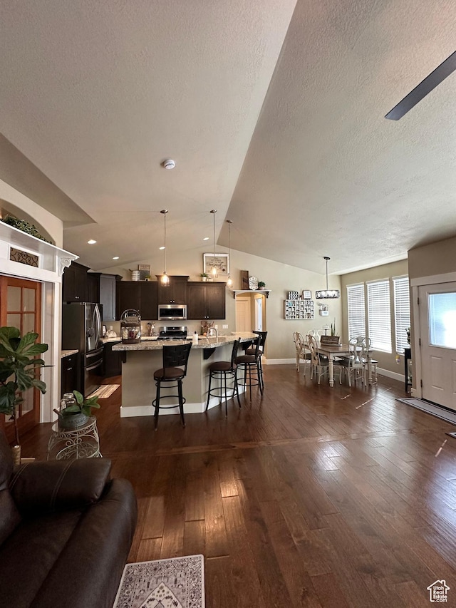 338 S 1230 E, Tooele, UT 84074 - living area with a textured ceiling, baseboards, dark wood-style floors, and vaulted ceiling