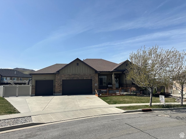 338 S 1230 E, Tooele, UT 84074 - view of front of house featuring a front yard, an attached garage, fence, a gate, and driveway