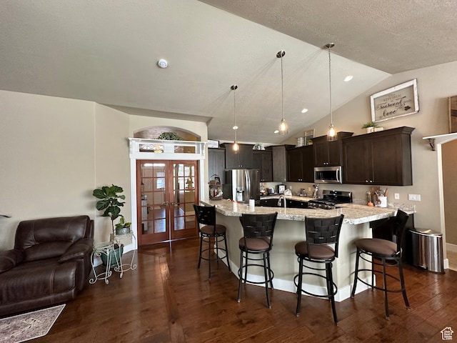 338 S 1230 E, Tooele, UT 84074 - kitchen featuring open floor plan, dark wood-style floors, french doors, a breakfast bar area, and stainless steel appliances