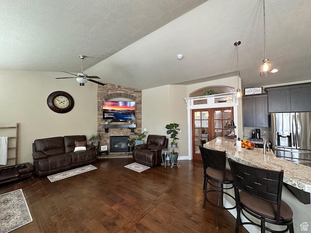 338 S 1230 E, Tooele, UT 84074 - living area featuring a fireplace, dark wood-type flooring, a textured ceiling, a ceiling fan, and lofted ceiling