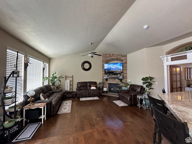 338 S 1230 E, Tooele, UT 84074 - living room featuring a stone fireplace, ceiling fan, a textured ceiling, dark wood finished floors, and vaulted ceiling