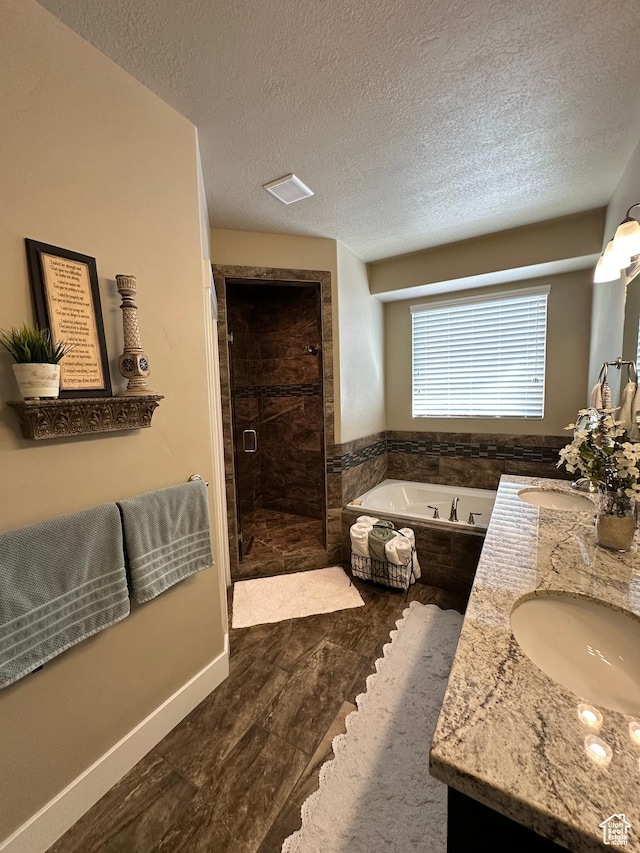 338 S 1230 E, Tooele, UT 84074 - bathroom featuring a bath, a textured ceiling, a sink, a stall shower, and double vanity