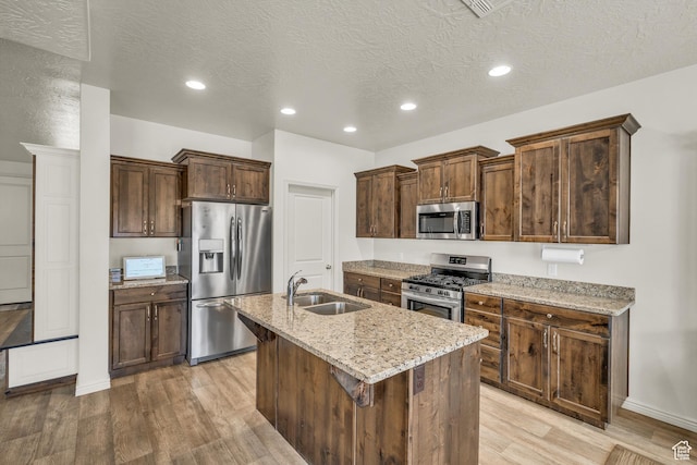 6116 S Rocky Talus Way, St George, UT 84790 - kitchen with stainless steel appliances, a sink, a kitchen island with sink, and light wood-style floors