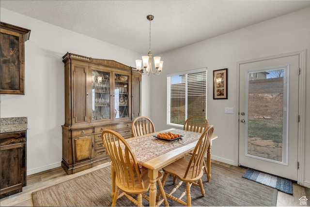 6116 S Rocky Talus Way, St George, UT 84790 - dining area featuring a healthy amount of sunlight, a notable chandelier, light wood-style flooring, and baseboards