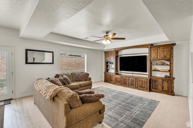 6116 S Rocky Talus Way, St George, UT 84790 - living room featuring a textured ceiling, a raised ceiling, visible vents, and baseboards