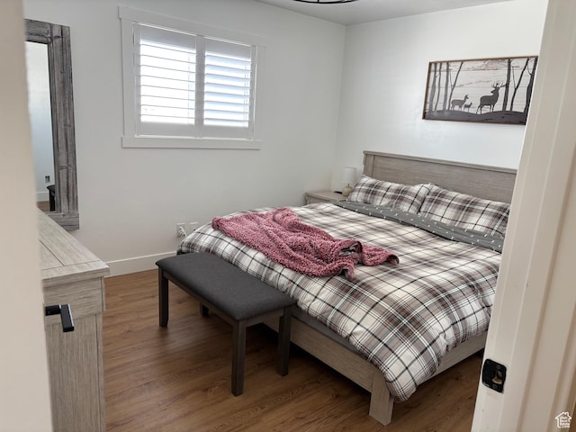 bedroom with baseboards and wood finished floors