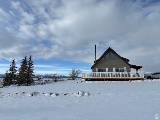 snow covered property with a deck