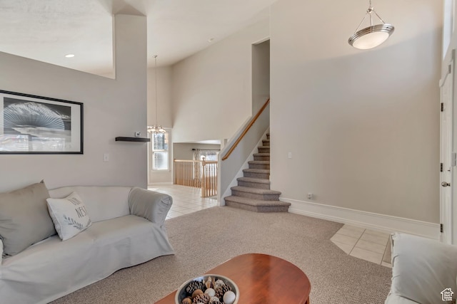 tiled living area featuring stairs, baseboards, and a towering ceiling