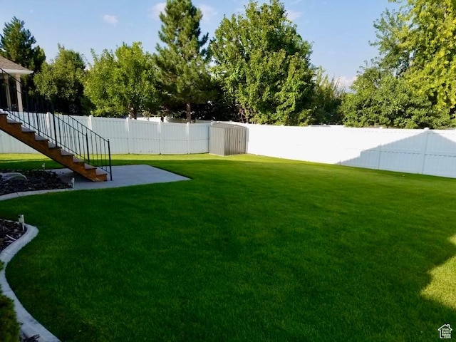 view of yard featuring stairway and a fenced backyard